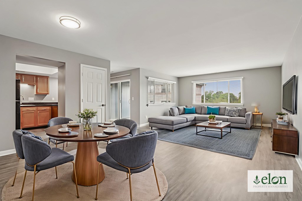 A modern living room with a dining table and chairs.
