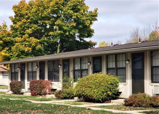 a white house with a porch and bushes
