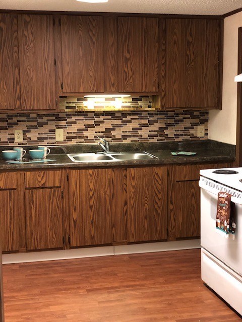 A kitchen with wooden cabinets and a white dishwasher.