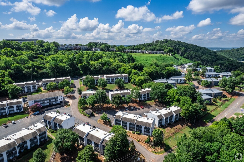 A bird's eye view of a residential complex surrounded by greenery.