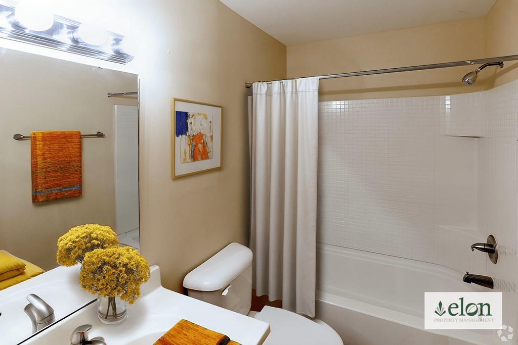 A bathroom with a white tub and a white chair.