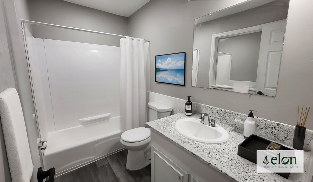 A bathroom with a white toilet, sink, and bathtub.