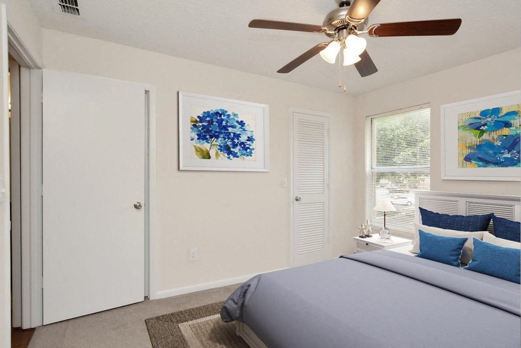 A bedroom with a bed and a ceiling fan at Aqua Bay Apartments in Naples, FL 34116