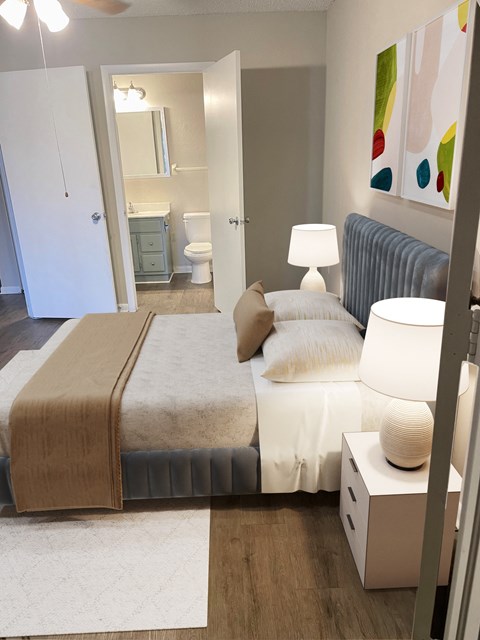 a bedroom with a bed and a bathroom at Aqua Bay Apartments in Naples, FL 34116