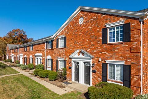 A row of red brick houses with black shutters.