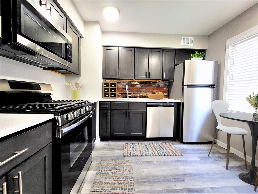 a kitchen with black cabinets and white appliances