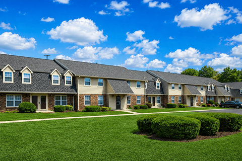 A row of houses with green lawns in front.