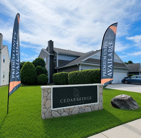 A sign for Cedarbridge Villas in front of a house.