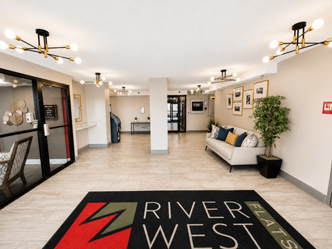A living room with a rug that says River West.