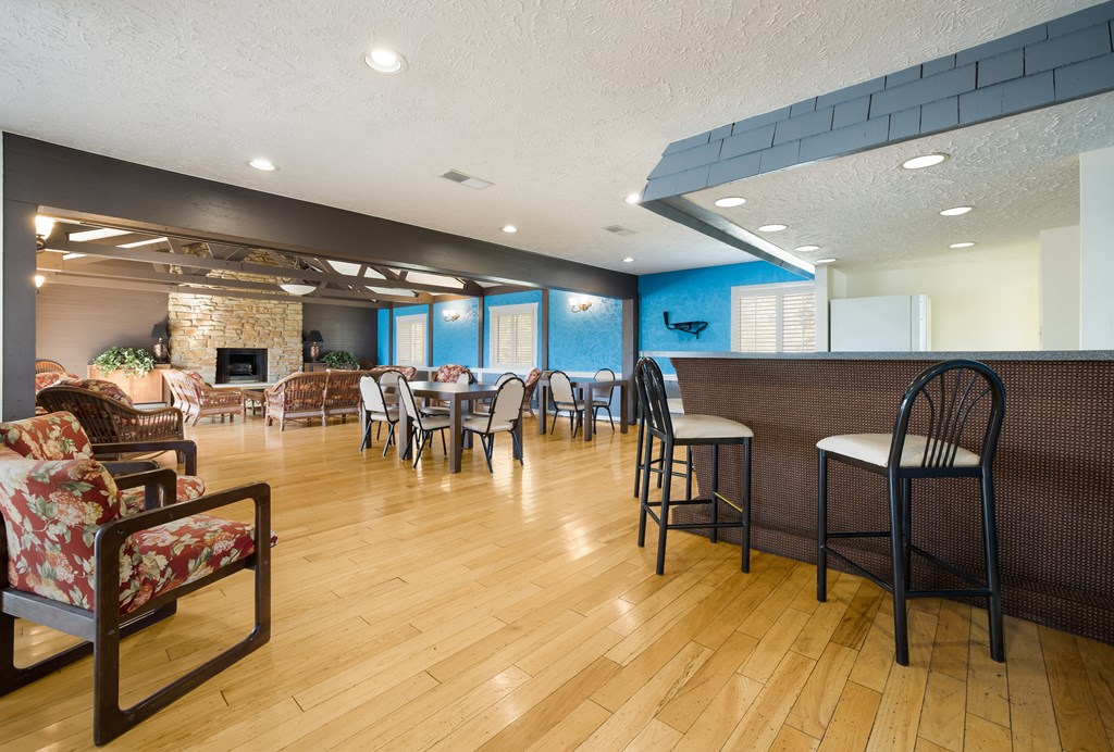 a resident clubhouse with hardwood floors and a fireplace