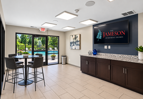 A modern office space with a bar area and a view of the outdoors.