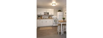 A kitchen with white appliances and wooden floors.