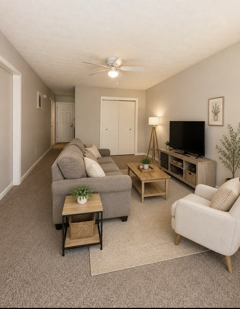 A living room with a grey couch, a wooden coffee table, and a flat screen TV.
