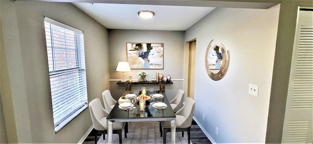 a dining room with a table and chairs and a window