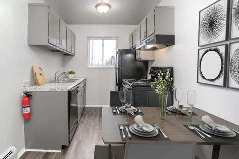 A modern kitchen with a dining table set for two.