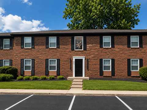 A red brick building with a white door and windows.