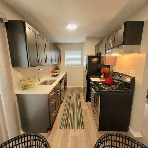 Kitchen with stainless steel appliances and dark wooden cabinets. 