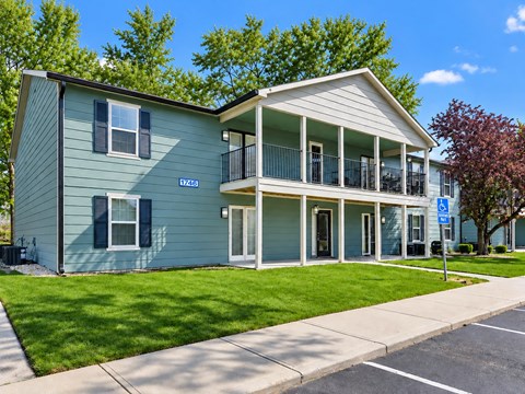 A blue house with a balcony and a sign on the front.