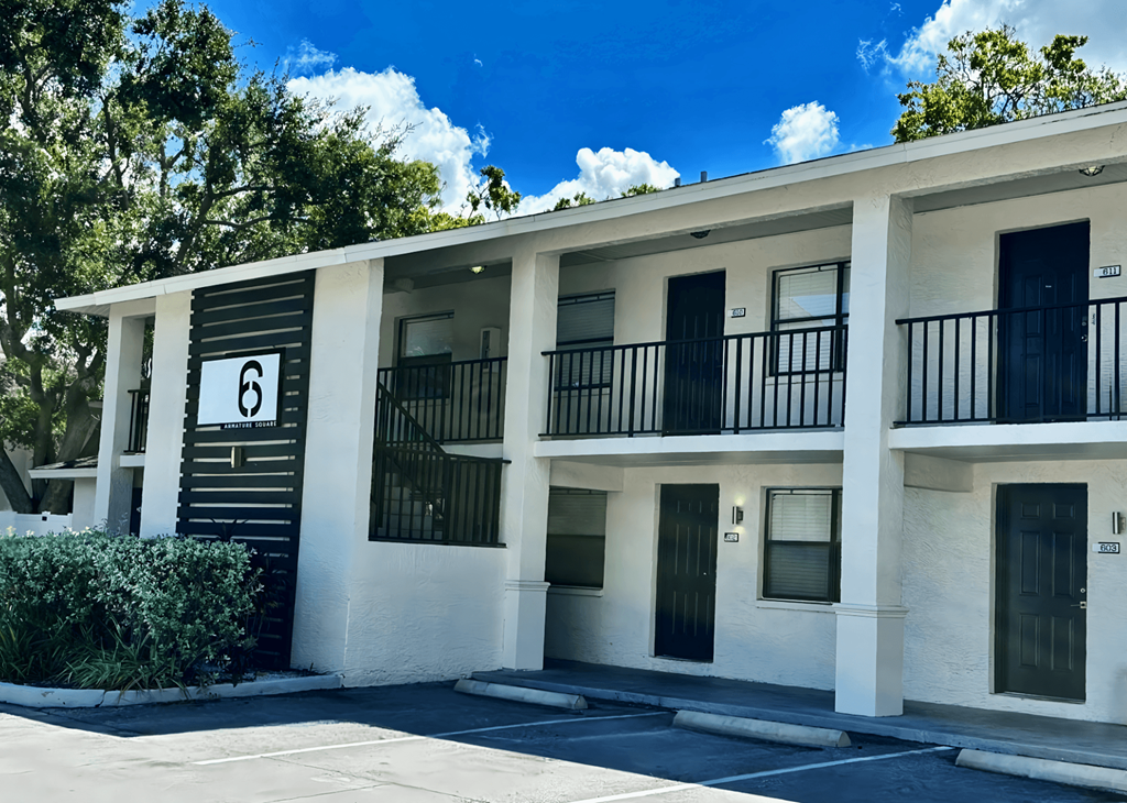 Apartment building number 6 with black balconies and doors.