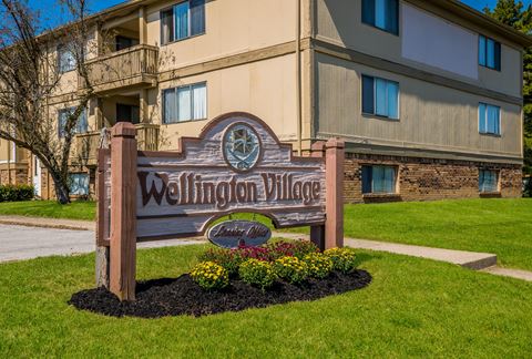 a picture of the wellington village sign in front of the building