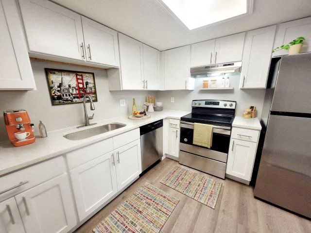 Kitchen with stainless steel appliances and white cabinets. 