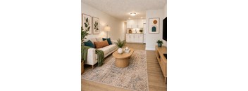 A living room with a white couch, a coffee table, and a rug.
