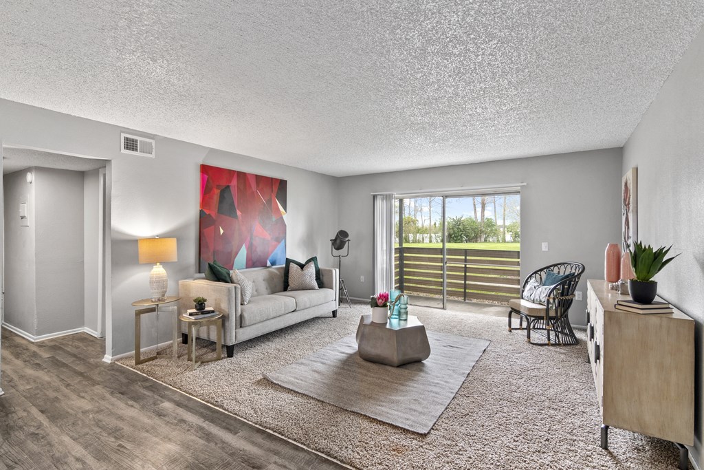 a living room with a couch and a chair and a sliding glass door
