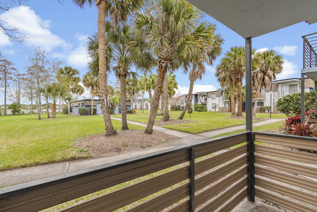 the view from the deck of a house with palm trees