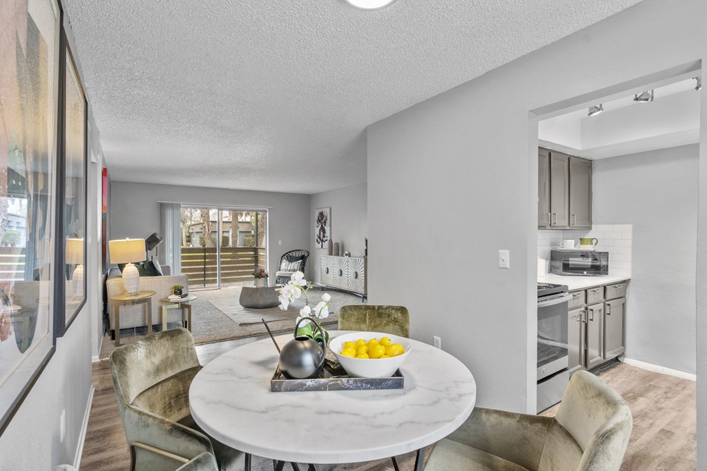 a living room and dining room with a table and chairs and a kitchen