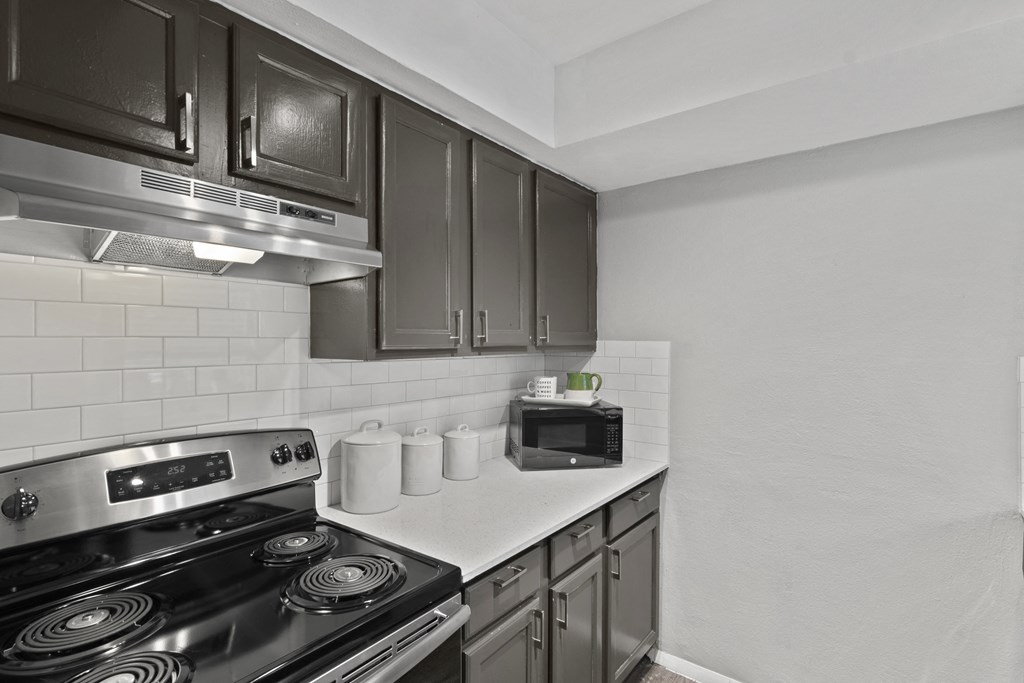 an empty kitchen with a stove and a microwave