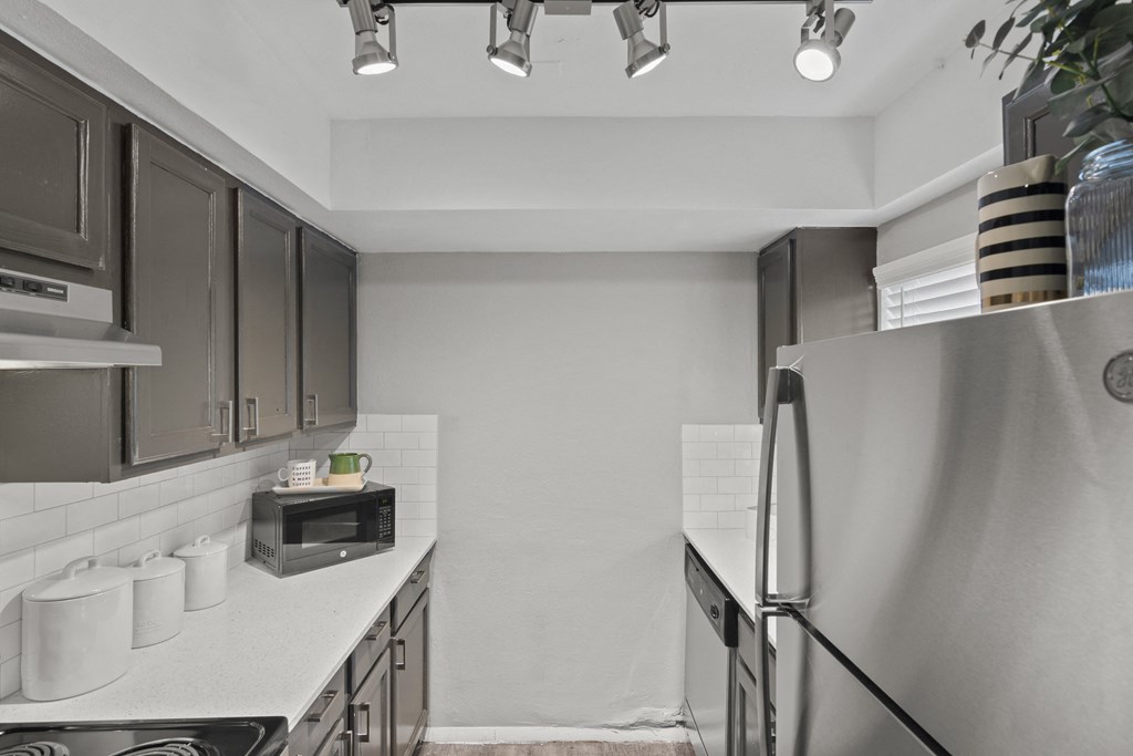 a kitchen with stainless steel appliances and white counter tops