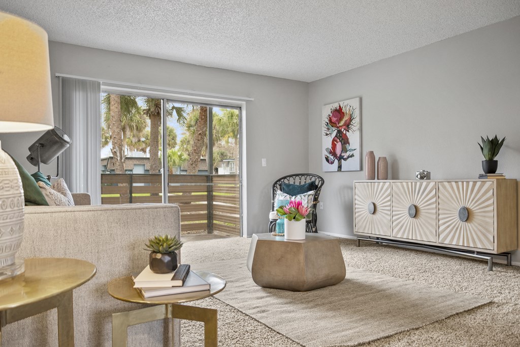 a living room with a couch and a chair and a sliding glass door