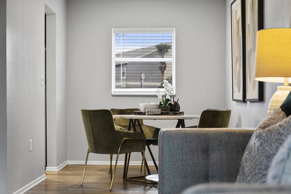 a living room with a table and chairs and a window