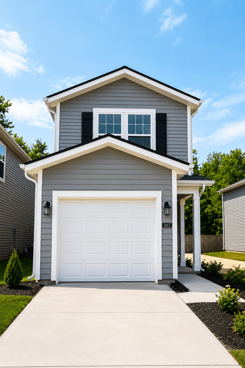 A house with a grey and white exterior and a white garage door.