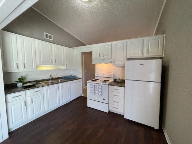 a kitchen with white cabinets and a white refrigerator
