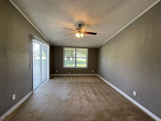 an empty living room with a ceiling fan