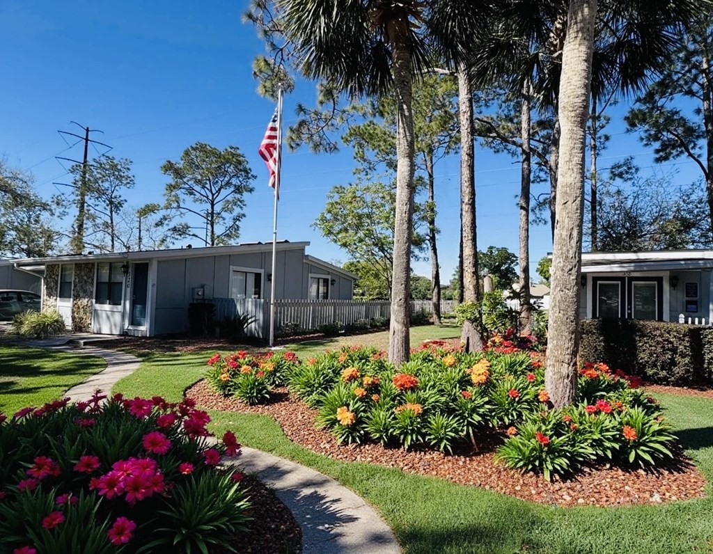 A house with a flag on the front lawn.