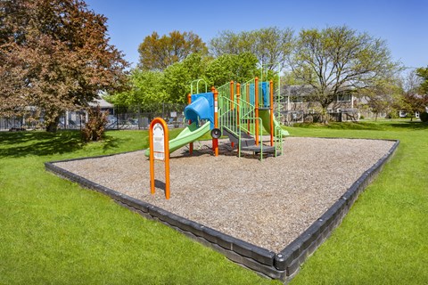 A playground with a slide and a climbing frame.