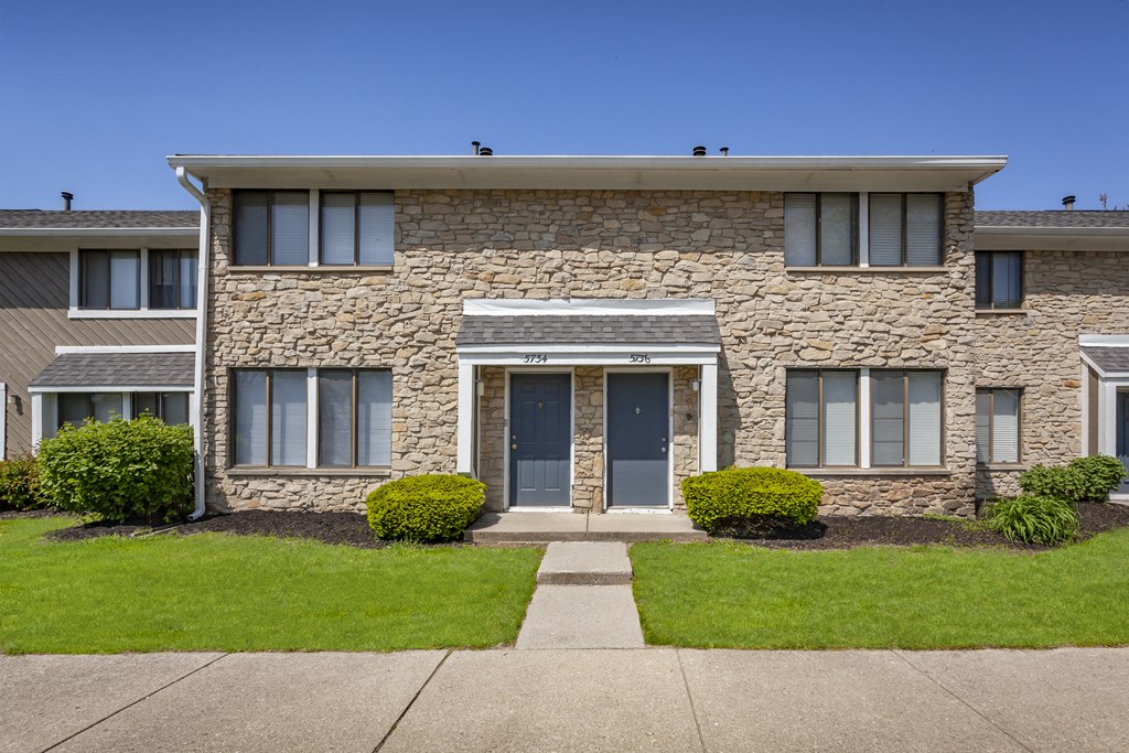 an apartment building with a sidewalk in front of it