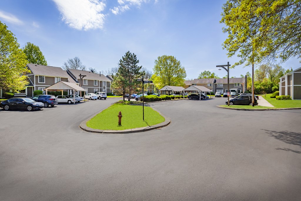 the view of a street with houses and cars in a parking lot