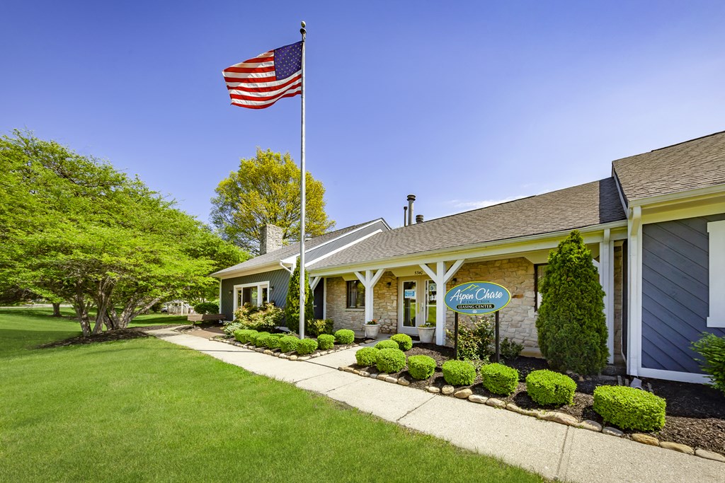 the front of a house with an flag on the pole
