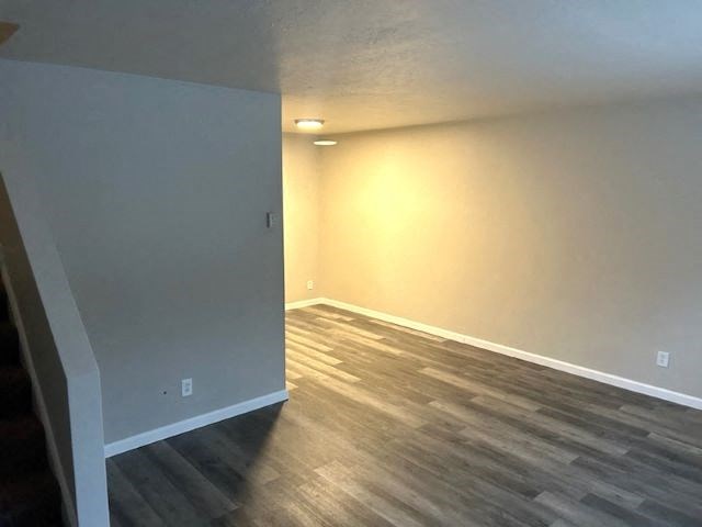 a empty room with wood floors and a white wall