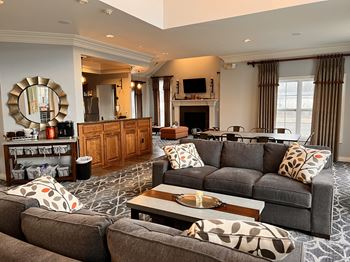 A living room with a grey couch and a wooden cabinet.
