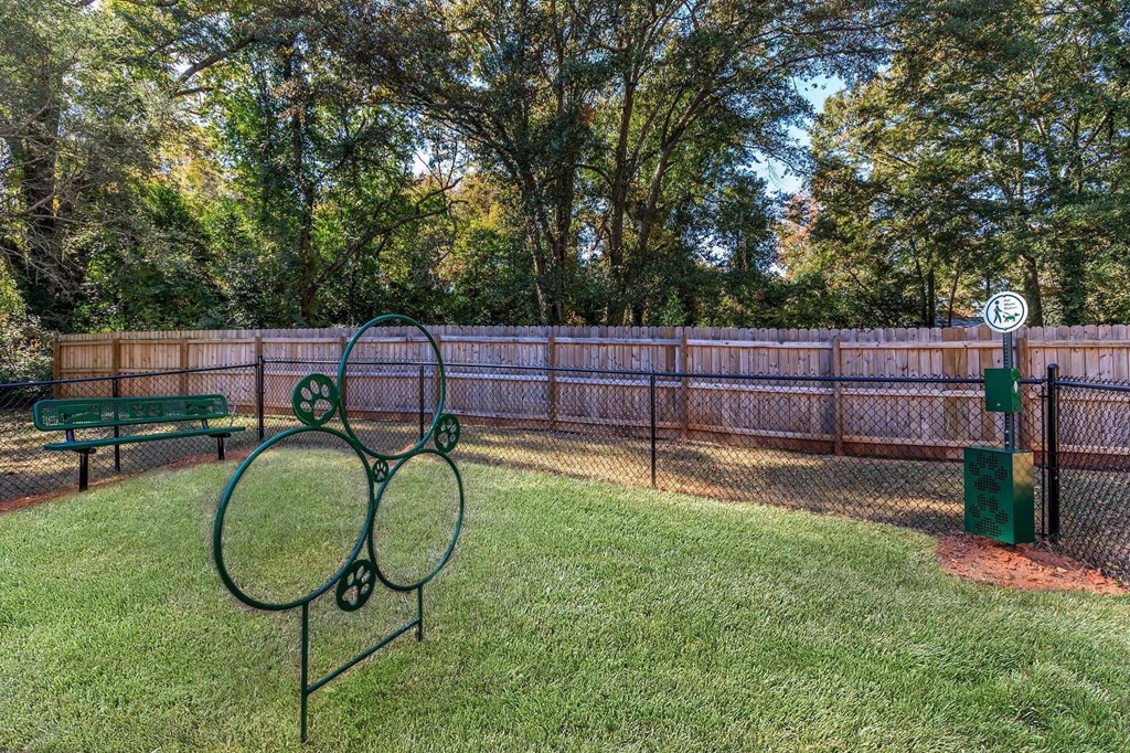 a tennis court in a fenced in area with a bench