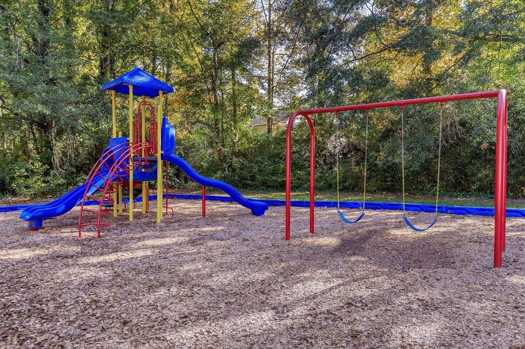 a playground with a blue and red swing set