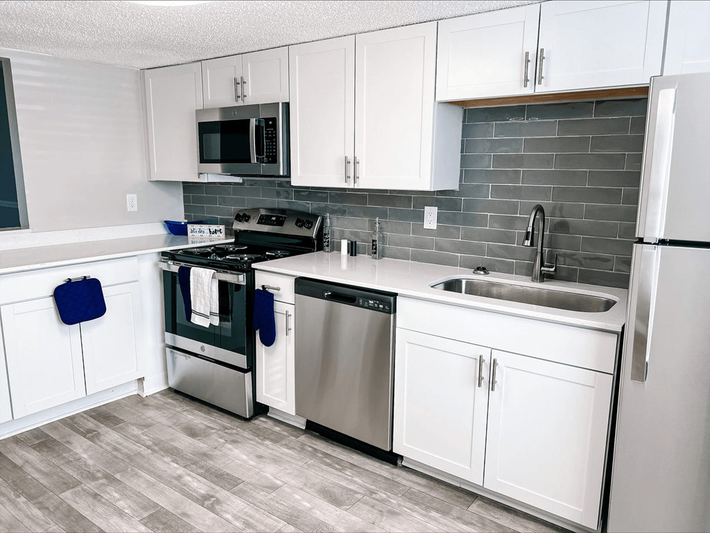 A kitchen with white cabinets and a black stove top.