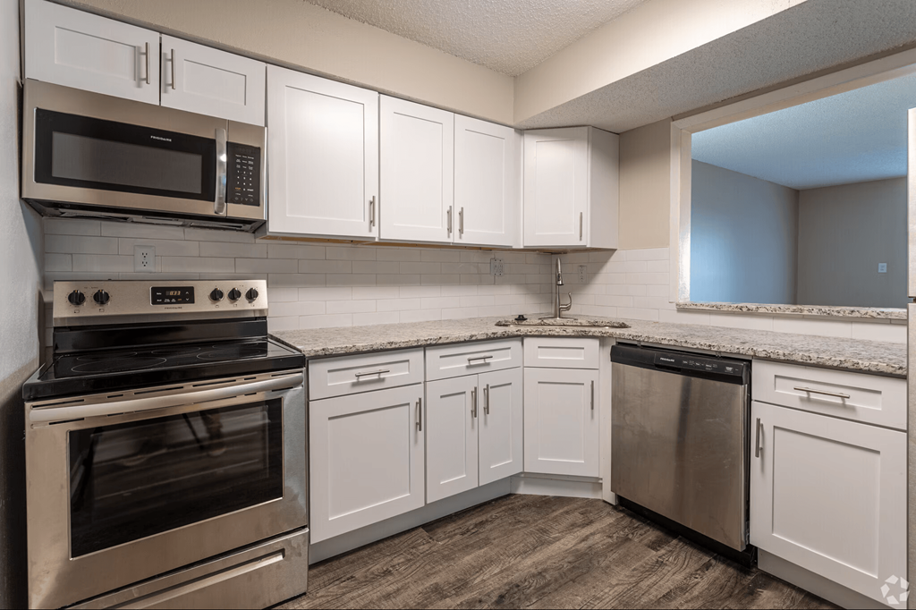 A kitchen with white cabinets and stainless steel appliances.