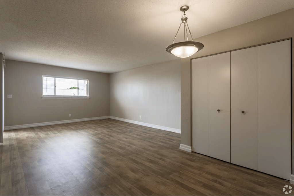 A room with a wooden floor and a window.