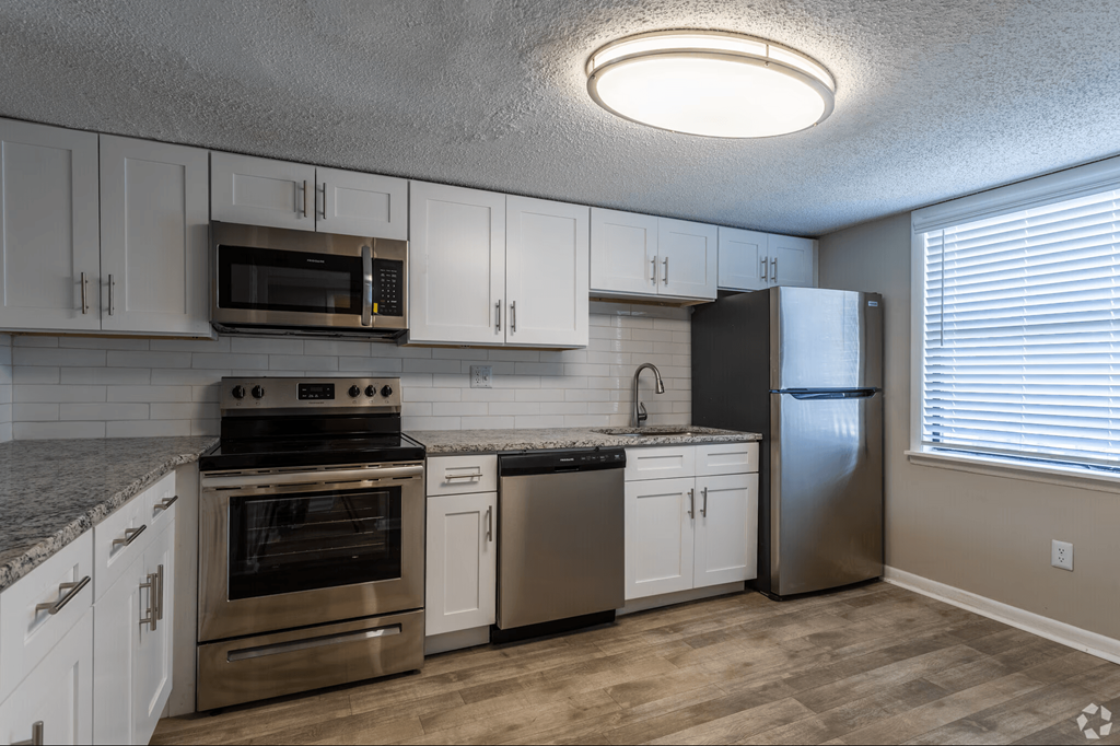 A kitchen with stainless steel appliances and white cabinets.