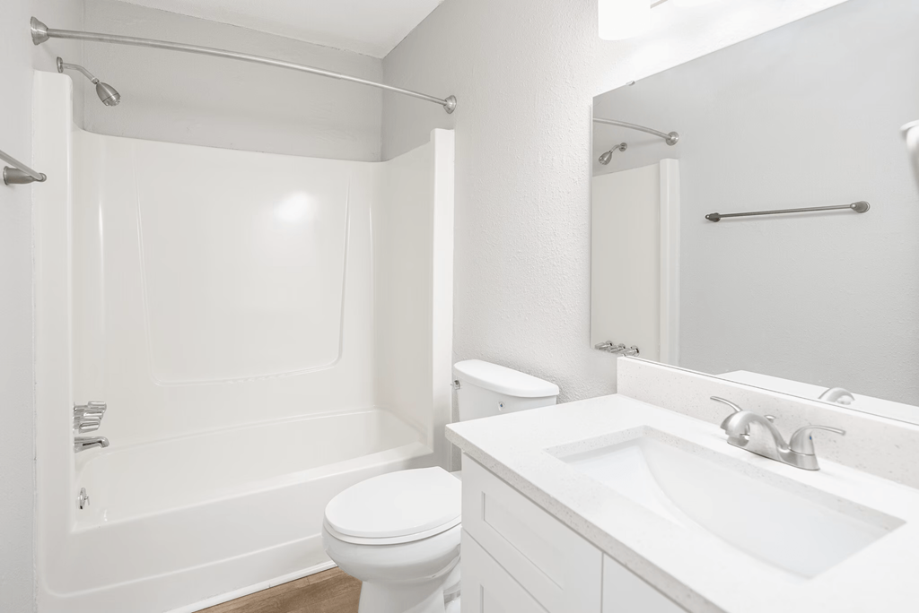 A white bathroom with a toilet, sink, and bathtub.